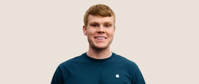 Un dipendente Apple Retail sorridente con i capelli corti biondo scuro.