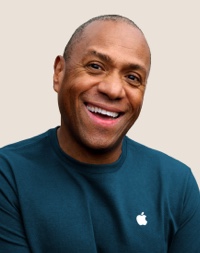 Un dipendente Apple Retail sorridente con i capelli corti grigio scuro.