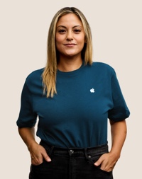 Una dipendente Apple Retail sorridente con i capelli lunghi biondo scuro.