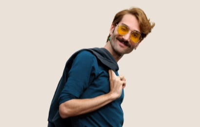 Un dipendente Apple Retail sorridente con i capelli corti biondo scuro e gli occhiali da vista.