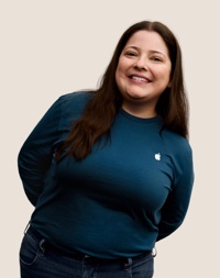 Una dipendente Apple Retail sorridente con i capelli lunghi scuri.