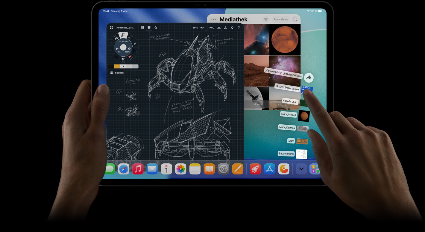 iPad Pro, Vorderansicht, Querformat, die rechte Hand bewegt sich über die nach oben aufgefächerten Dateien im Downloads Ordner, das Display zeigt die iPadOS 26 Benutzeroberfläche mit mehreren geöffneten Apps, darunter eine App zum Bearbeiten von Fotos mit detaillierten Roboterdesigns und handschriftlichen Anmerkungen sowie mehreren Designstufen und der Fotomediathek