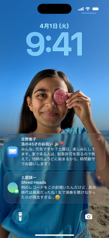 5つのiPhoneのモデル。各モデルが隣のモデルと少しずつ重なっている。左端の画面にはメッセージアプリの背景を設定した会話、左から2番目の画面にはカラフルなアプリのアイコンを表示したホーム画面、中央のモデルには写真、Liquid Glassでできた時刻を表す数字、画面下部に2つの通知を表示したロック画面、右から2番目のモデルにはクリアなLiquid Glassでできたアプリのアイコン、右端のモデルにはLiquid Glassのミュージックプレイヤーが映し出されている