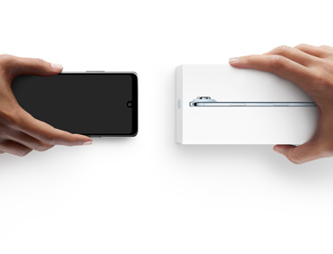 Mains échangeant des téléphones, téléphone Android sans coffret à gauche, nouvel iPhone 17 Pro dans son coffret à droite