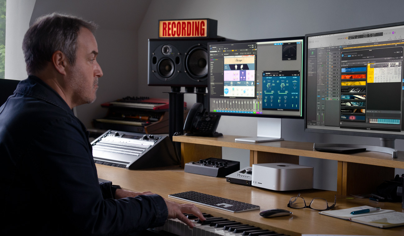 Een musicus maakt audiomixen op een piano in combinatie met Mac Studio en Studio Display