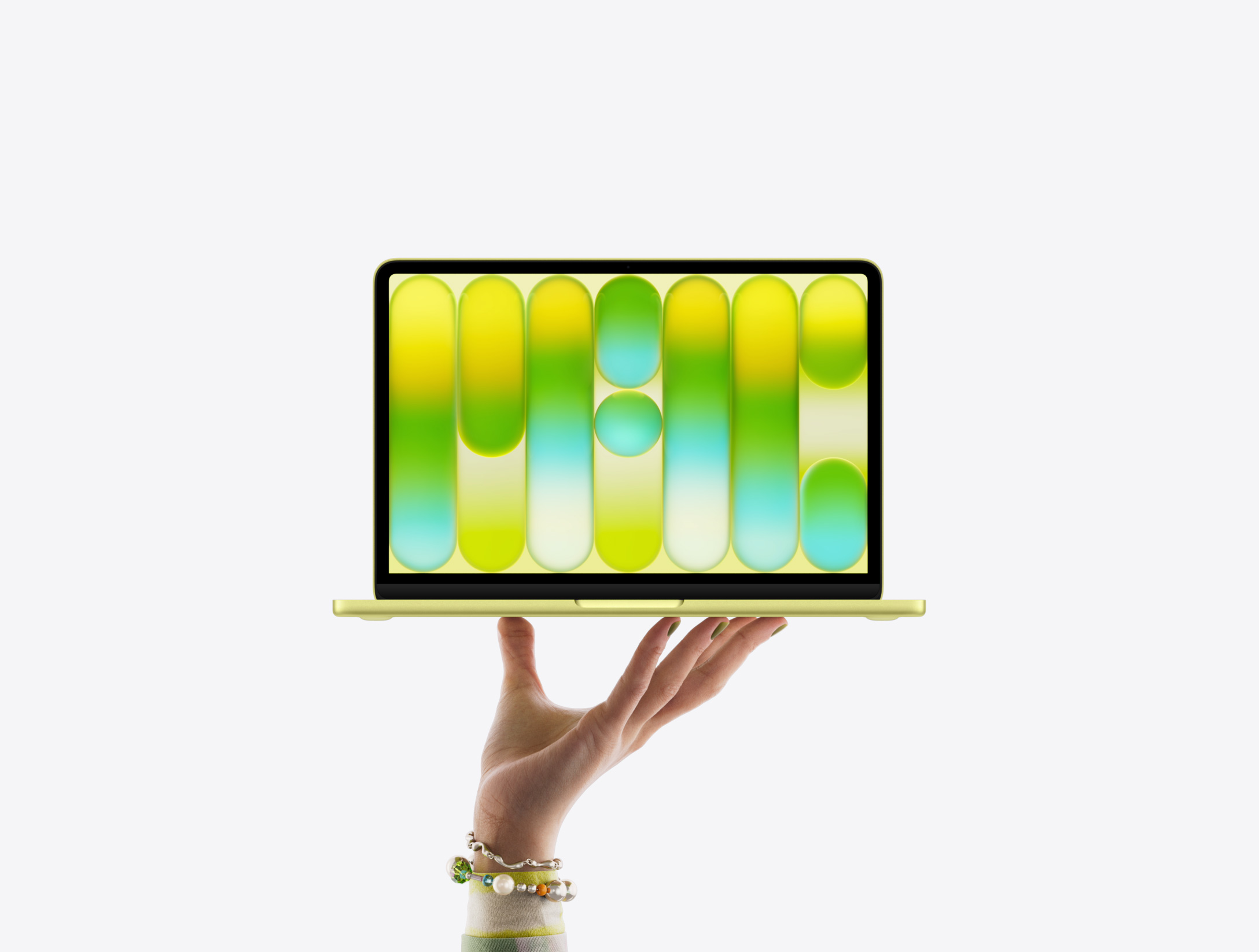 Ein MacBook Neo in der Farbe Zitrus wird auf den Fingerspitzen einer geöffneten Hand balanciert, das Display zeigt ein farbiges, abstraktes Muster